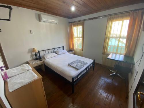 a bedroom with a bed and a table and windows at PORT APART in Antalya