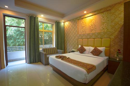 - une chambre avec un lit, une chaise et une fenêtre dans l'établissement Q Saina S K Regency Rishikesh, à Rishikesh
