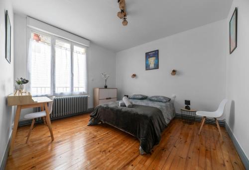 une chambre avec un lit, une table et un bureau dans l'établissement L'Alliotaux - Appartement calme et design - Parking gratuit, à Vichy