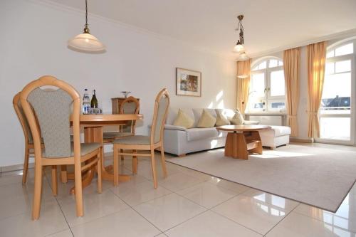 uma sala de estar com uma mesa e cadeiras e um sofá em Residenz Bismarck, Whg 11 em Westerland