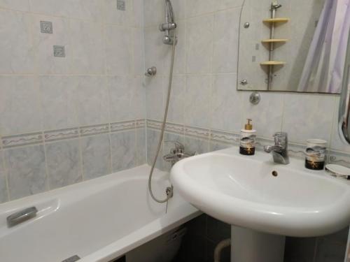 een badkamer met een wastafel en een bad bij Центр Гостеприимства in Aqtöbe