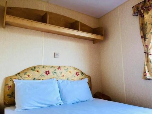 a bedroom with a bed with blue pillows at MDL Holiday Let in Rhyl