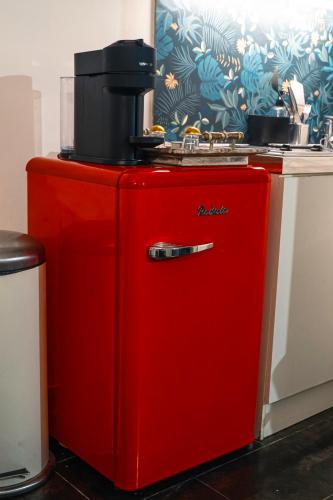 Elle comprend un réfrigérateur rouge et une cafetière. dans l'établissement Studio très agréable, à Neuilly-sur-Marne
