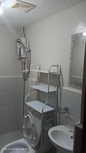 a bathroom with a toilet and a sink at Tranquil Cool Studio Condo Mactan Cebu in Lapu Lapu City