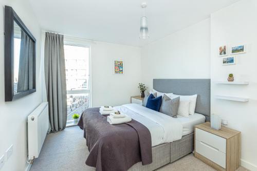 倫敦的住宿－Modern New 2BR flat wBalcony in peaceful Brixton，一间卧室设有一张大床和一个窗户。