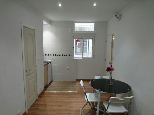 une chambre avec une table, des chaises et une fenêtre dans l'établissement Apartamentos EconoStay Barbieri 1, à Madrid