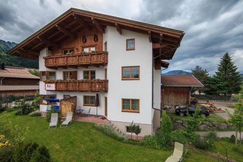 ein großes weißes Haus mit Holzdach in der Unterkunft Ferienwohnungen Bauernhof Andreas Kleiner in Tannheim