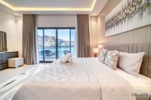 a bedroom with a bed and a view of the water at Grand 4BR Villa with Assistant's and Driver's Room Al Dana Island Fujairah by Deluxe Holiday Homes in Fujairah