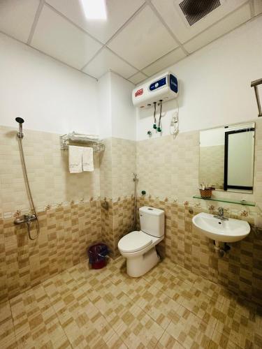 een badkamer met een toilet en een wastafel bij KHÁCH SẠN NHÀ HÀNG SO OANH 