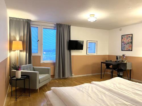 a bedroom with a bed and a chair and a desk at 2Home Hotel Apartments in Solna
