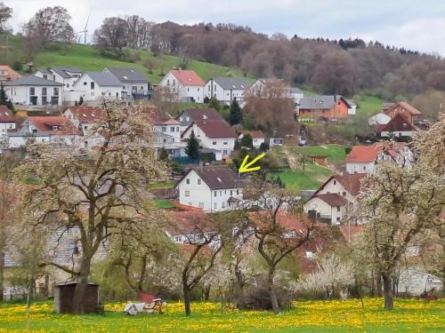 a village with houses and a yellow arrow in the sky at Ferienwohnungen Seelenglück in Oberdrackenstein