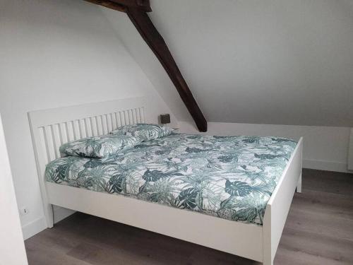 a bedroom with a white bed with a green blanket at Appartement avec vue sur Loire in Blois