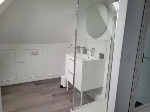 a white bathroom with a sink and a mirror at Appartement avec vue sur Loire in Blois