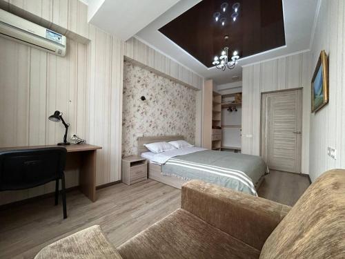 a bedroom with a bed and a desk and a couch at AURA on Ryskulov street 30 in Bishkek