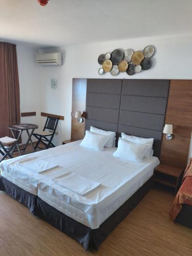 a bedroom with a large bed and a table at Guest House Skalite in Sozopol