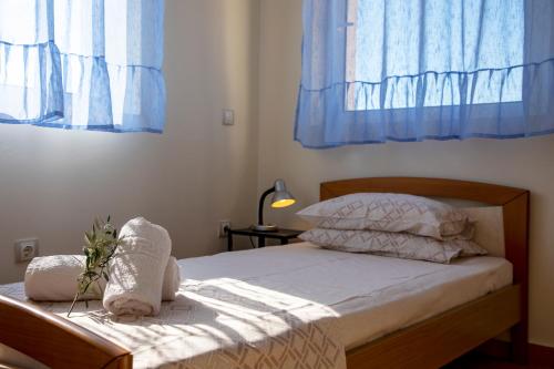 a bedroom with a bed with blue curtains at Aegina Sea View Villa in Aegenitissa