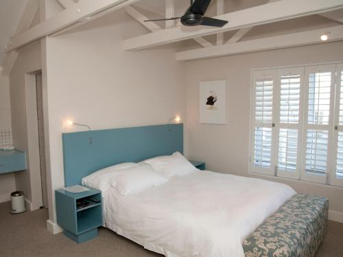 クニスナにあるCrow's Nestのベッドルーム1室(大型ベッド1台、青いヘッドボード付)