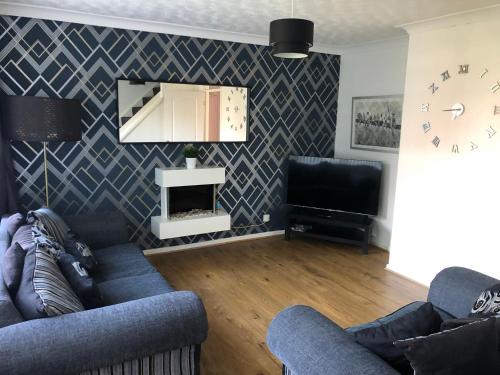 a living room with two couches and a television at Ainsdale Gardens in Birmingham