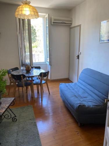 un salon avec un canapé bleu et une table dans l'établissement Chez FERNAND-Vues sur les montagnes, à Arles-sur-Tech