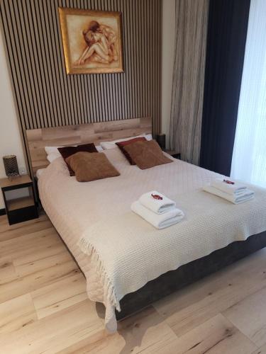 a bedroom with a large bed with two towels on it at Apartament przy Starówce in Elblag