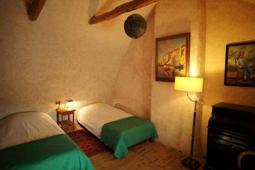 - une chambre avec 2 lits et une lampe dans l'établissement Gîte éco-responsable exceptionnel pour 6 ou 8 personnes secteur gorges du Tarn, à Le Recoux