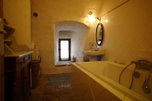 a bathroom with a bath tub and a sink at Gîte éco-responsable exceptionnel pour 6 ou 8 personnes secteur gorges du Tarn in Le Recoux