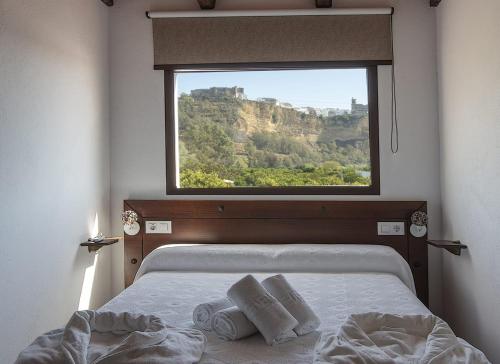 a bedroom with a bed with a large window at Villa Los Llanos in Arcos de la Frontera