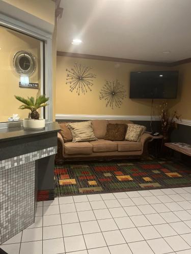 a living room with a couch and a flat screen tv at Regency Inn & Suites in Anoka