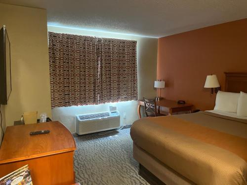 a hotel room with a bed and a window at Regency Inn & Suites in Anoka