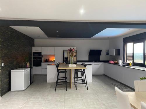a kitchen with white cabinets and a table and chairs at Villa des Grenadelles in Saint-Paul