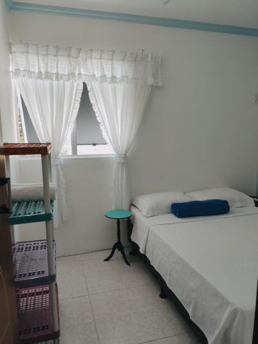 a bedroom with a bed and a ladder and a window at Alu Azul 1 in Barra de São Miguel