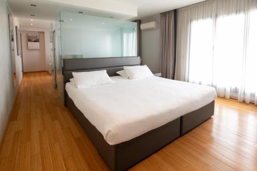 a bedroom with a large bed with white sheets at Galzignano Resort Terme & Golf - Hotel Majestic in Galzignano