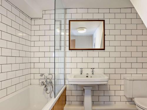 Baño de azulejos blancos con lavabo y aseo en 3 Bed in Bala 91365, en Bala
