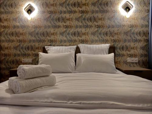 - un lit avec des oreillers et des serviettes blancs dans l'établissement 2-х комнатная квартира (евродвушка), à Kyzylorda
