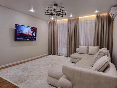 Il comprend un salon doté d'un canapé et d'une télévision à écran plat. dans l'établissement 2-х комнатная квартира (евродвушка), à Kyzylorda