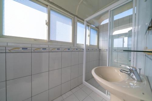 五結鄉的住宿－河風精緻民宿，白色的浴室设有水槽和窗户。
