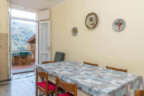 ein Esszimmer mit einem Tisch, Stühlen und einem Fenster in der Unterkunft Palazzo Marchesale, vista mare in Pisciotta