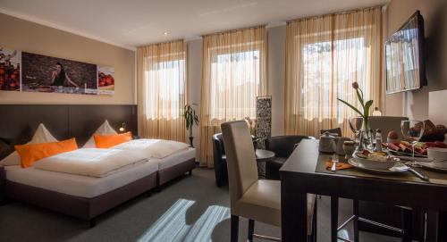慕尼黑的住宿－GS酒店，一间卧室配有一张床铺和一张桌子,还有一间用餐室