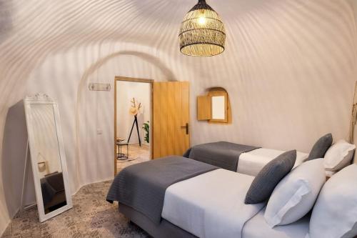 - une chambre avec 2 lits et un miroir dans l'établissement Mystagoge Retreat cave with an indoor pool and gym, à Vóthon