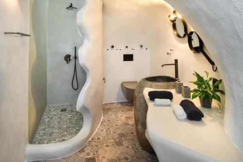 La salle de bains est pourvue d'une baignoire, de toilettes et d'un lavabo. dans l'établissement Mystagoge Retreat cave with an indoor pool and gym, à Vóthon