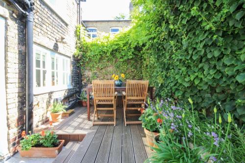 a patio with two chairs and a table with flowers at Spencer House in Sandwich