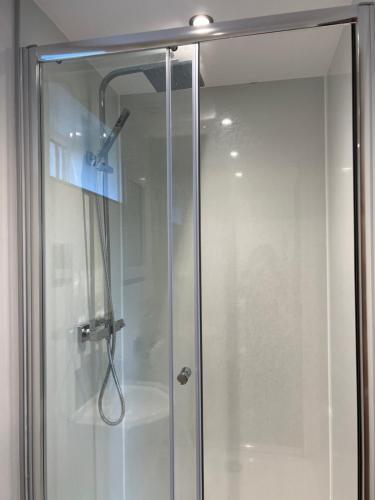 una doccia con porta in vetro in bagno di Comus inn a Selby