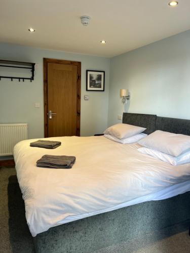 una camera da letto con un grande letto bianco con due asciugamani di Comus inn a Selby