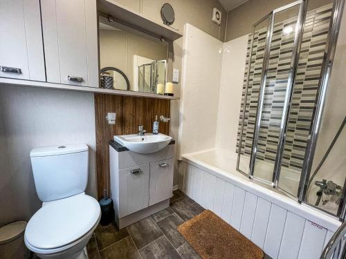 a bathroom with a toilet and a sink at Beautiful Caravan With Decking At Azure Seas Ref 32060az in Lowestoft