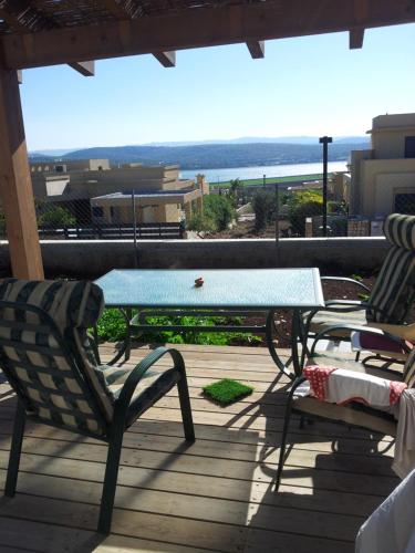 una mesa y sillas en una terraza con vistas al océano en Lakeview Chalet in the Galilee - Master Bedroom Sublet en Kafr Mandā