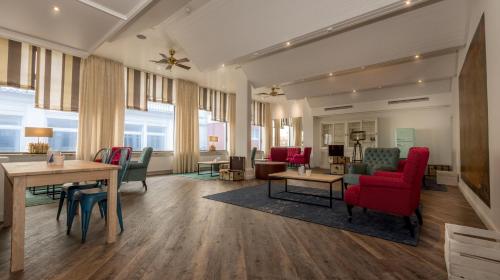 a large living room with red chairs and a table at Seehotel Borkum in Borkum
