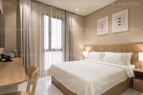 a bedroom with a large bed and a table at THE CODE RESIDENCE in Kuwait