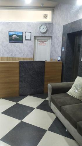 una sala d'attesa con divano e orologio sul muro di Vishram Inn a Alwar