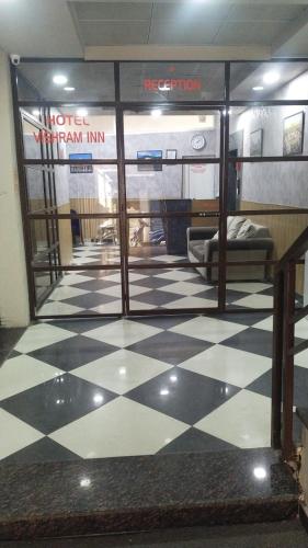 Habitación con litera y suelo a cuadros. en Vishram Inn, en Alwar