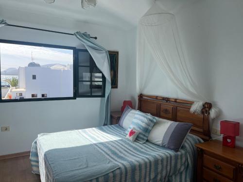 a bedroom with a bed and a large window at Romantico con piscina privada solo para ti in Punta Mujeres
